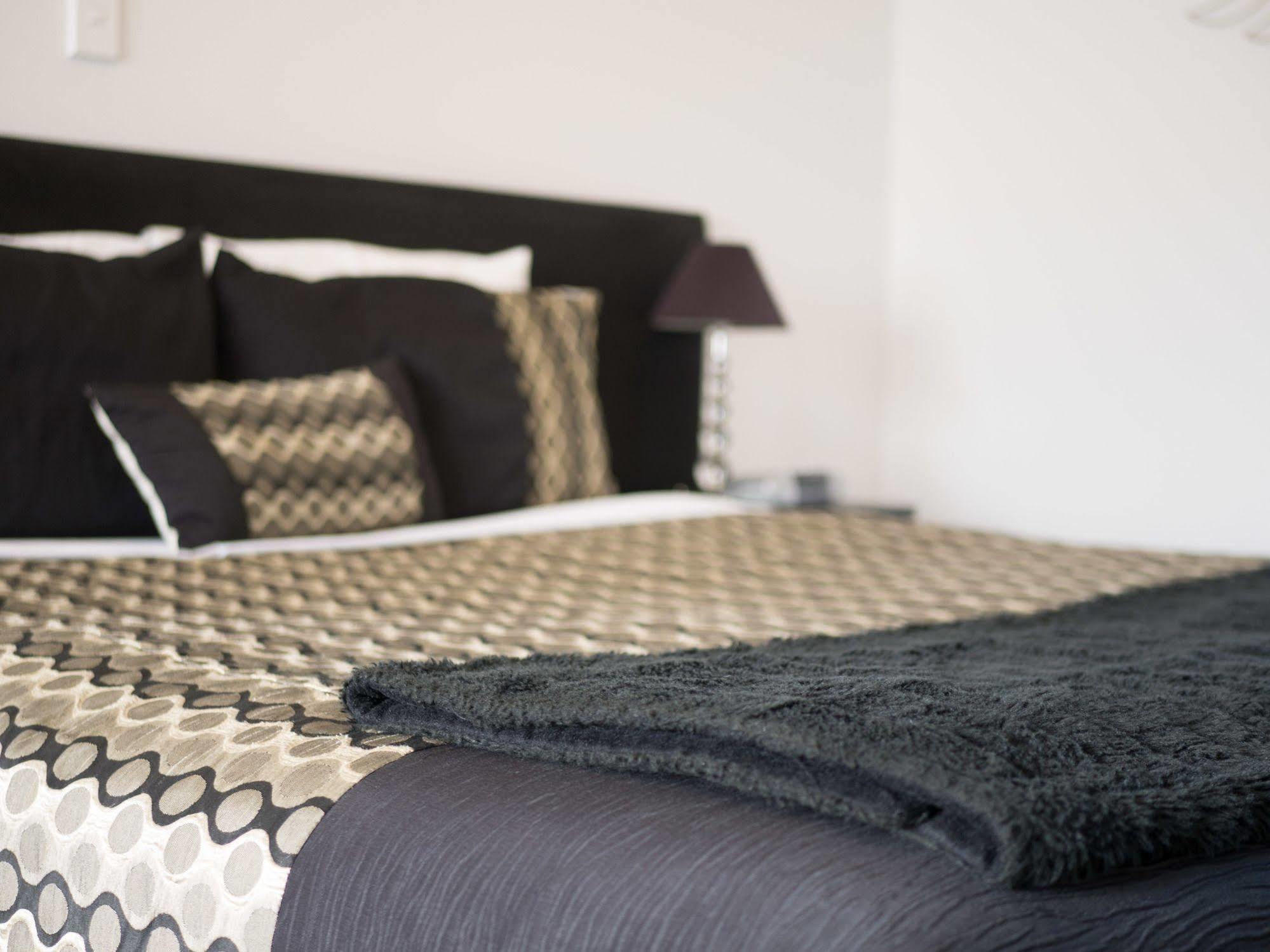 Bellano Motel Suites Christchurch Exteriér fotografie A bed with a throw